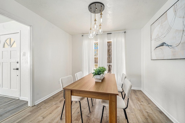 dining space featuring a textured ceiling and light wood-type flooring