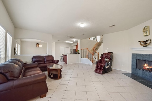 living room with light tile patterned flooring and a tiled fireplace