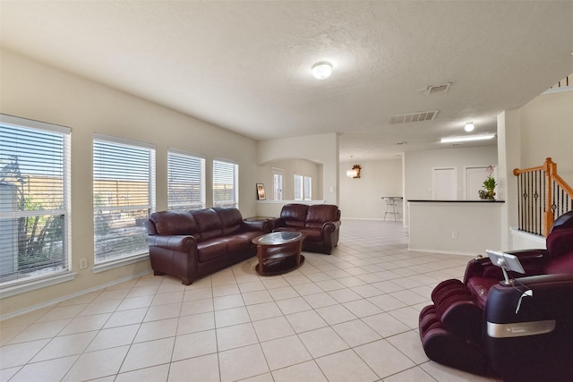 living room featuring a textured ceiling and light tile patterned flooring