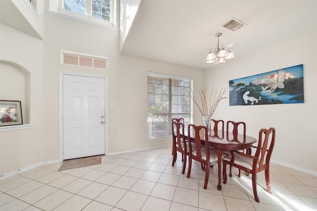 dining room featuring a notable chandelier, a high ceiling, and light tile patterned floors