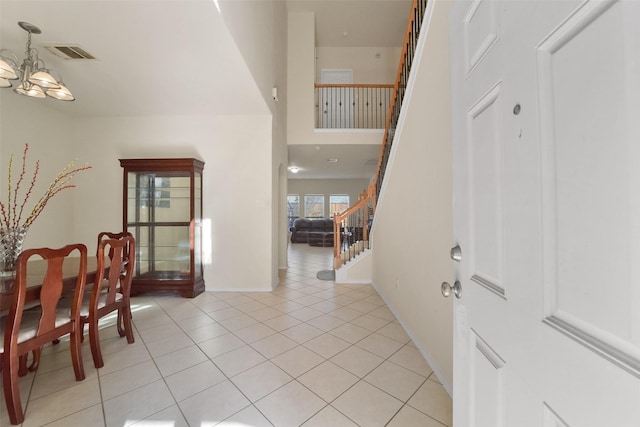 tiled entrance foyer with a notable chandelier