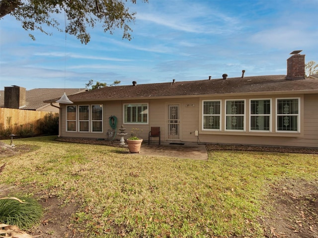 back of property with a yard and a patio area