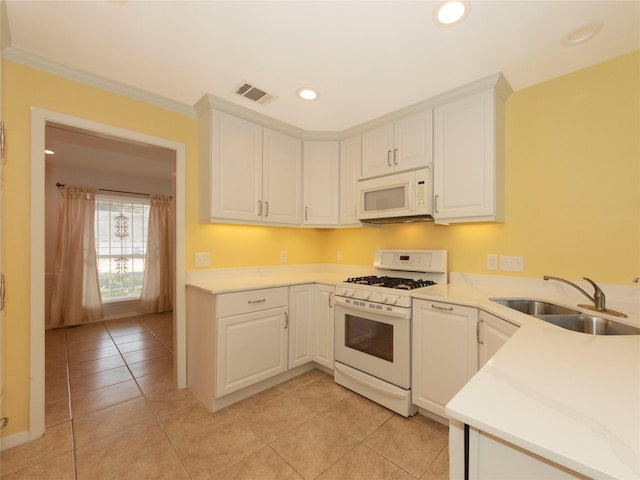 kitchen featuring light tile patterned flooring, white appliances, sink, and white cabinets