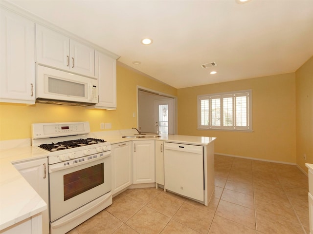 kitchen with white cabinetry, sink, light tile patterned floors, kitchen peninsula, and white appliances