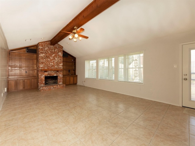 unfurnished living room with light tile patterned flooring, vaulted ceiling with beams, ceiling fan, a brick fireplace, and built in shelves