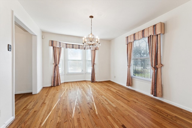 unfurnished dining area featuring hardwood / wood-style floors, a notable chandelier, and plenty of natural light