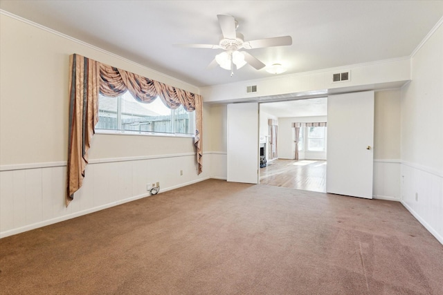 empty room featuring crown molding, carpet, and ceiling fan