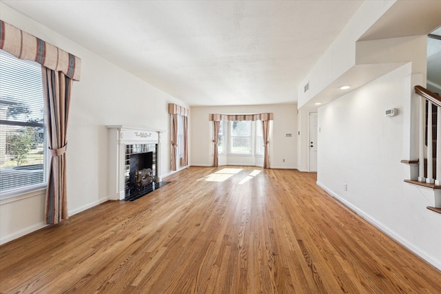 unfurnished living room featuring a fireplace and light hardwood / wood-style flooring