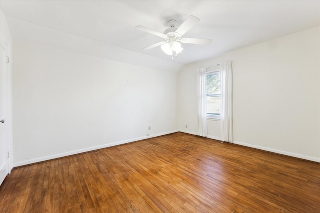 spare room with hardwood / wood-style floors, vaulted ceiling, and ceiling fan