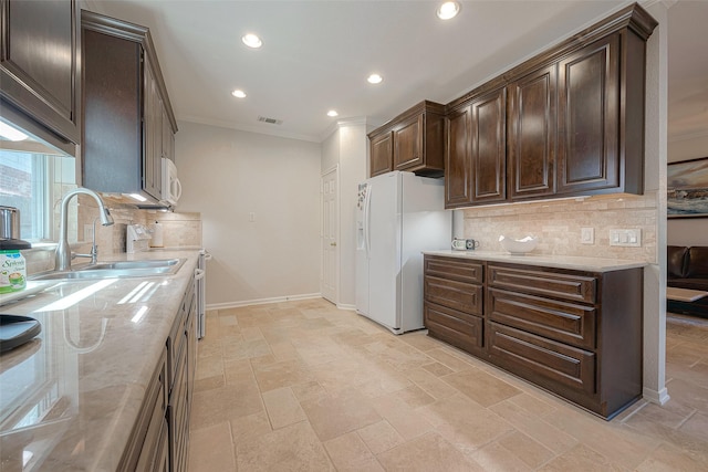 kitchen featuring sink, light stone counters, dark brown cabinets, white appliances, and backsplash