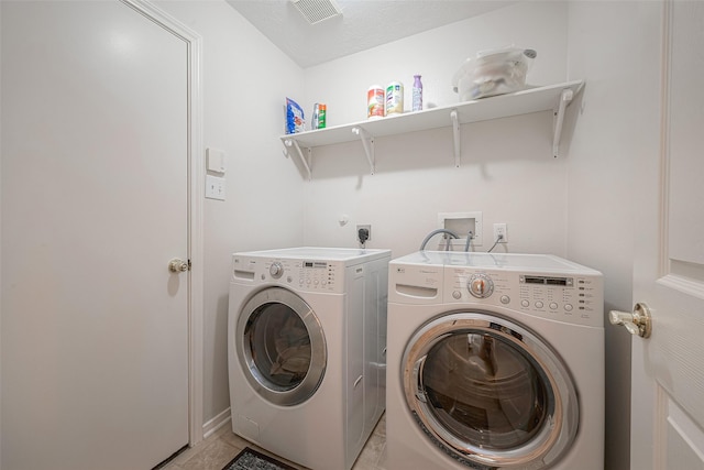 clothes washing area with washer and dryer and light tile patterned flooring