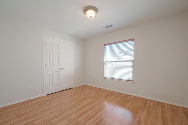 unfurnished bedroom with light hardwood / wood-style floors and a closet