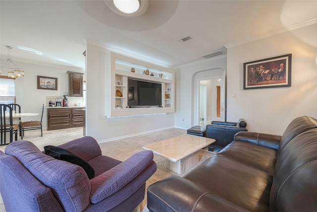 living room with crown molding, an inviting chandelier, and built in features