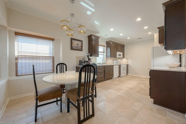 dining room featuring an inviting chandelier, sink, and crown molding