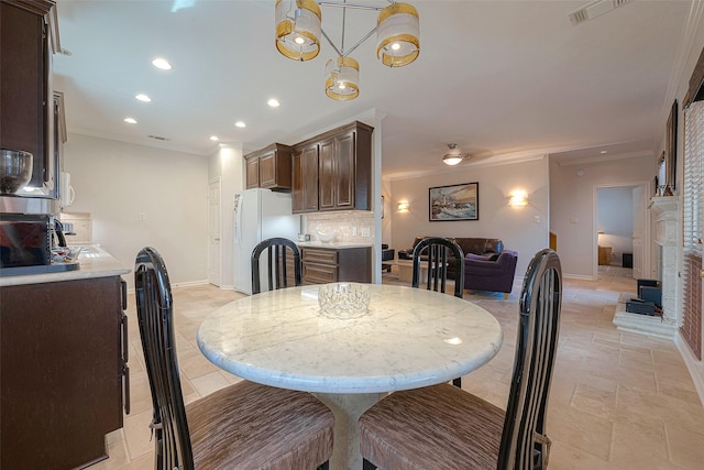 dining room with ornamental molding and a chandelier