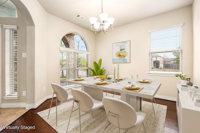 dining area featuring dark hardwood / wood-style floors and a notable chandelier