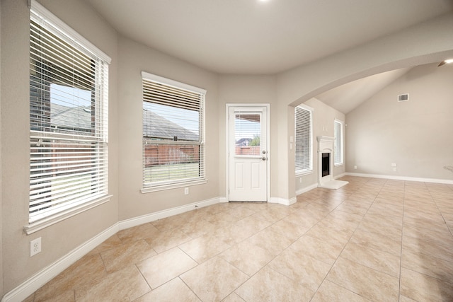 unfurnished living room featuring light tile patterned flooring and lofted ceiling