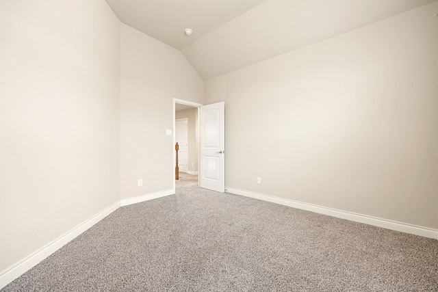 empty room featuring lofted ceiling and carpet floors