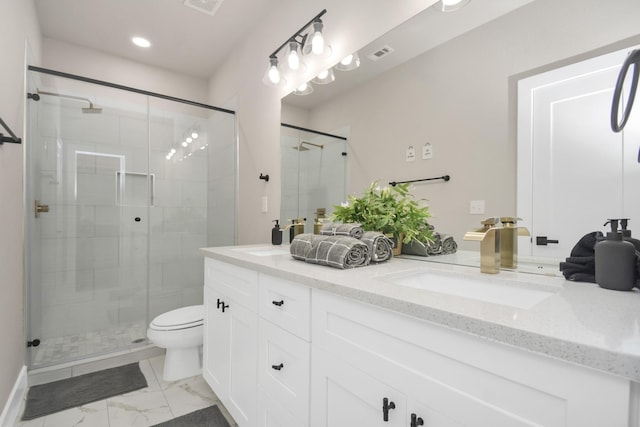 bathroom featuring vanity, a shower with door, and toilet