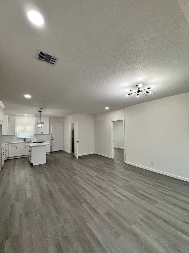 unfurnished living room with hardwood / wood-style floors and a textured ceiling