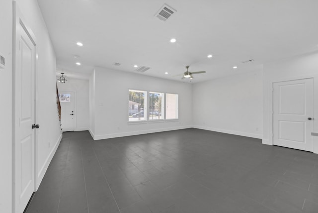 unfurnished room with ceiling fan with notable chandelier