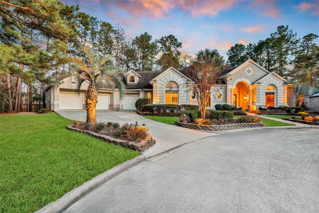 view of front of house with a garage and a lawn