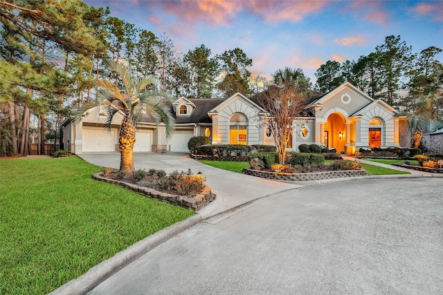 view of front of house with a garage and a lawn