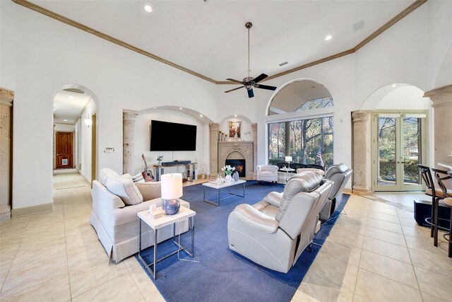 tiled living room with crown molding, a towering ceiling, and ceiling fan