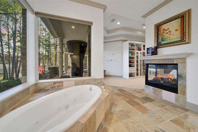 bathroom featuring a multi sided fireplace and tiled tub