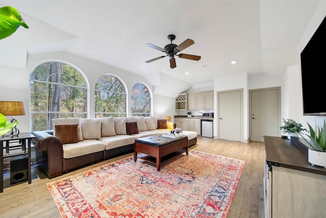 living room with lofted ceiling, light hardwood / wood-style flooring, and ceiling fan