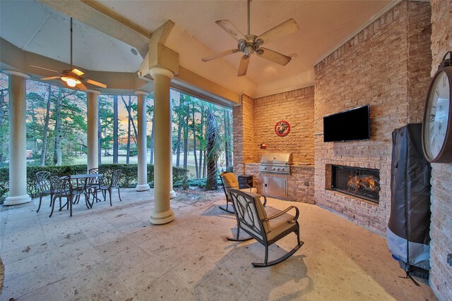 view of patio / terrace with area for grilling, a grill, and an outdoor stone fireplace