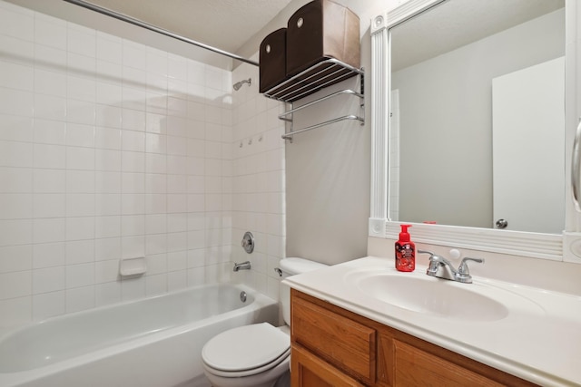 full bathroom with tiled shower / bath, vanity, and toilet