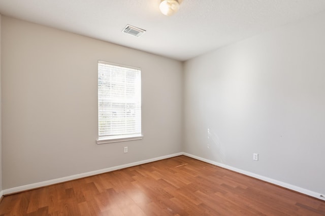 spare room featuring hardwood / wood-style floors and a wealth of natural light