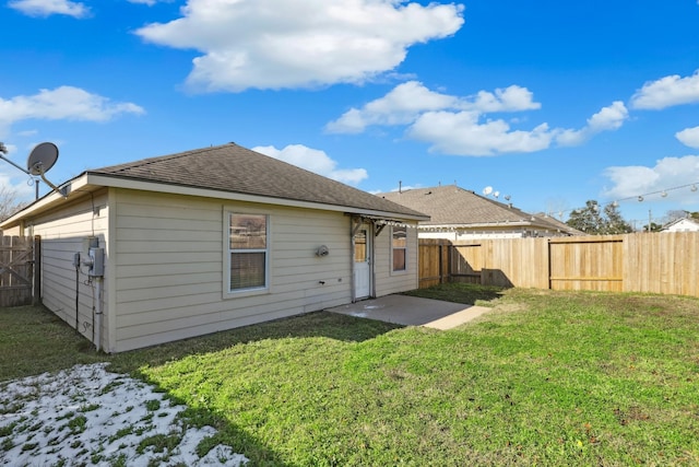 back of house with a patio and a lawn