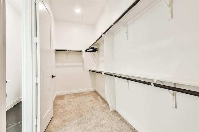 walk in closet featuring light colored carpet