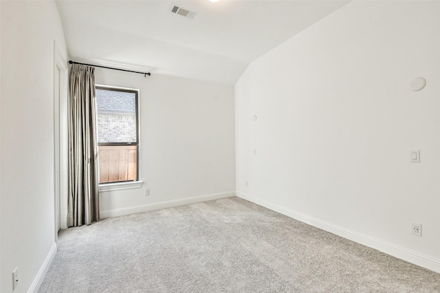 empty room with lofted ceiling and light carpet