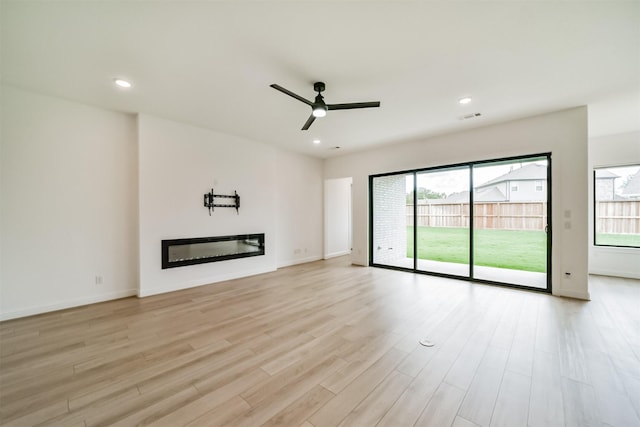 unfurnished living room with ceiling fan and light hardwood / wood-style floors