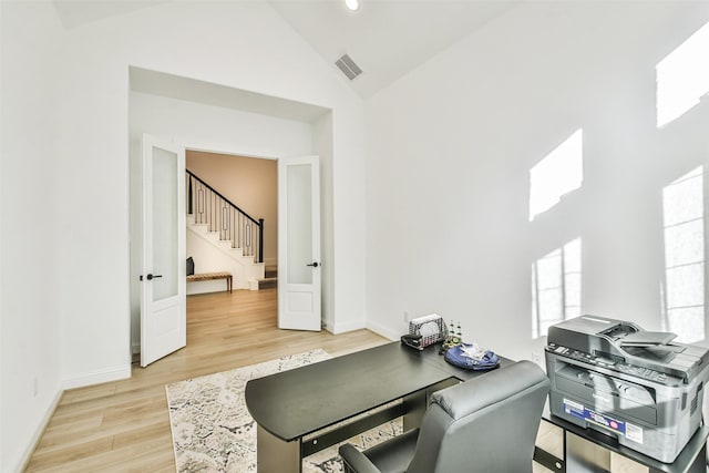 home office with lofted ceiling and light hardwood / wood-style floors