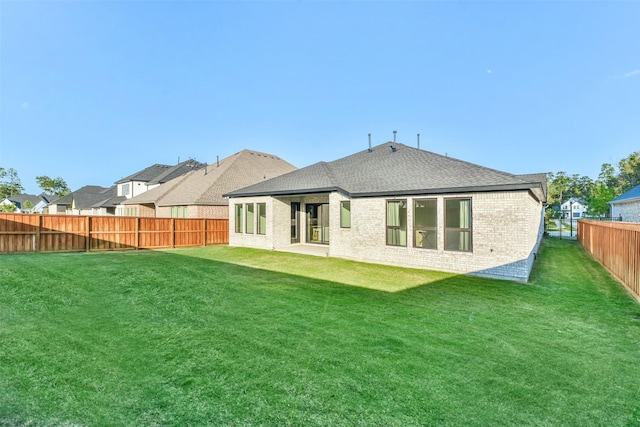 rear view of property featuring a patio and a yard