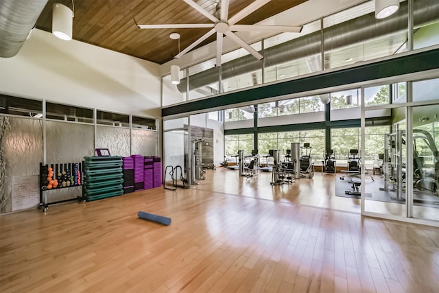 workout area featuring wood ceiling, a towering ceiling, and hardwood / wood-style flooring