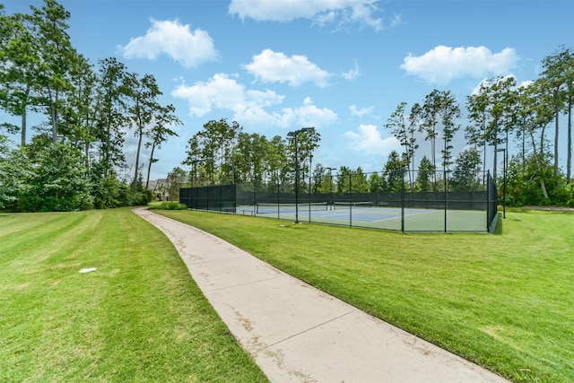 view of tennis court featuring a lawn