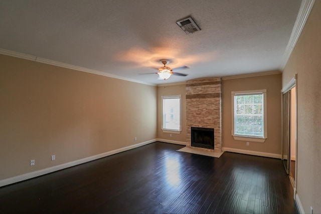 unfurnished living room with ornamental molding, a stone fireplace, and a healthy amount of sunlight