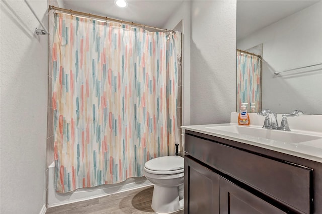 full bathroom with vanity, toilet, hardwood / wood-style floors, and shower / bath combo