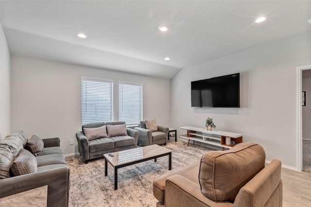 living room with light hardwood / wood-style flooring and vaulted ceiling