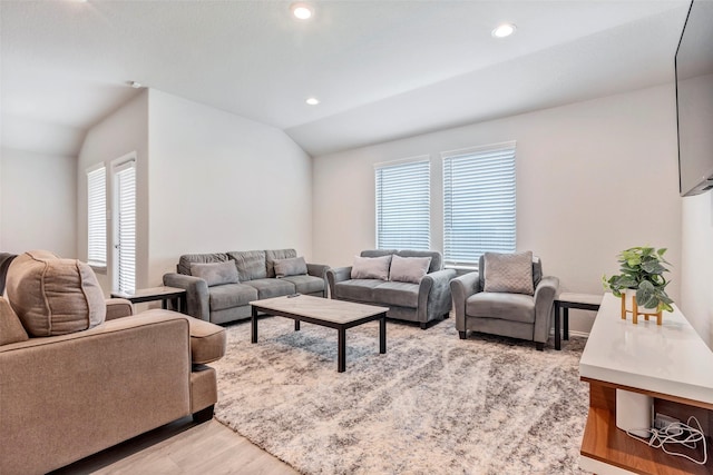 living room with vaulted ceiling and light wood-type flooring