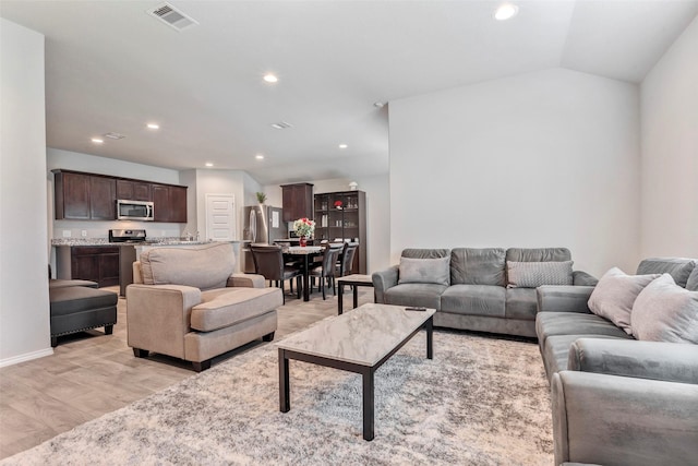 living room featuring vaulted ceiling and light hardwood / wood-style floors