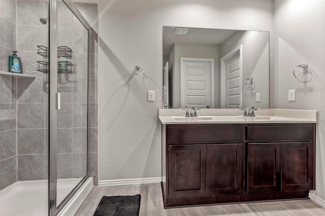 bathroom featuring vanity, hardwood / wood-style flooring, and a shower with door