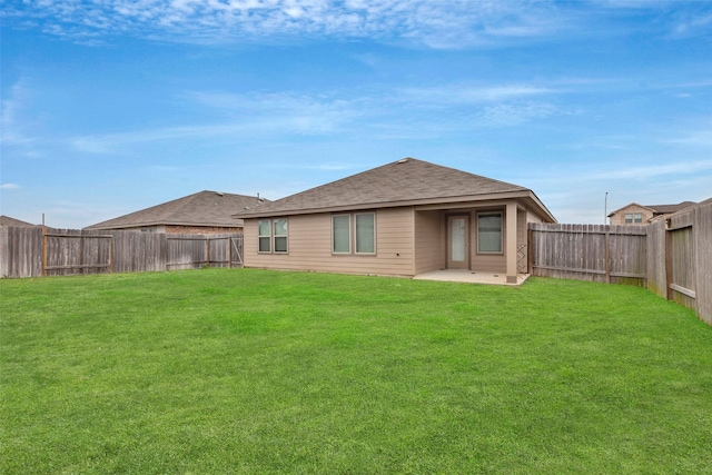 back of property with a yard and a patio area