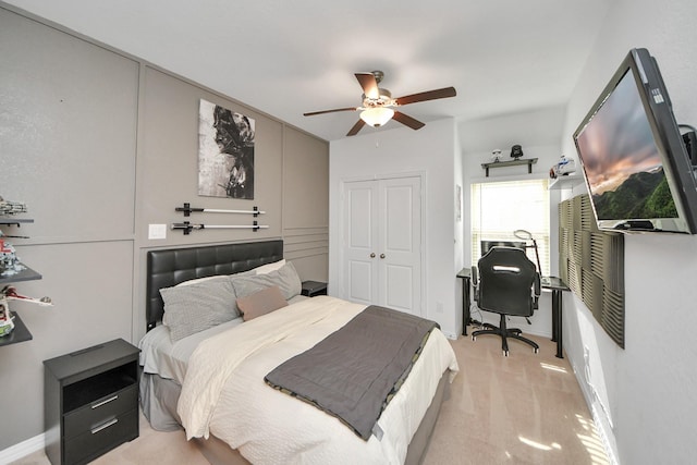 bedroom featuring light carpet, ceiling fan, and a closet