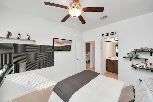 carpeted bedroom featuring ensuite bath and ceiling fan